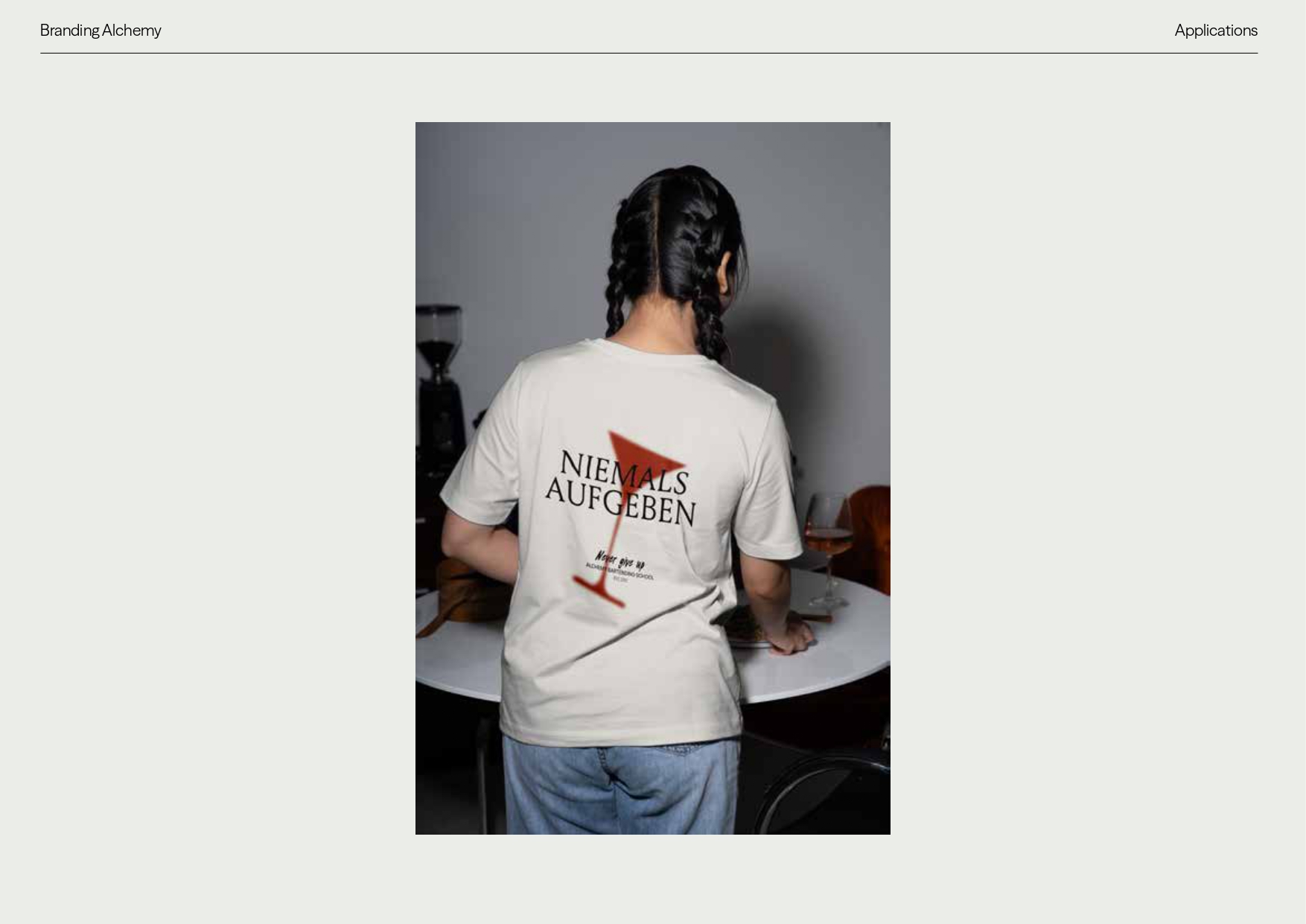 T-Shirt mit dem Aufdruck „Niemals Aufgeben“ – Textilapplikation der Alchemy Bartending School